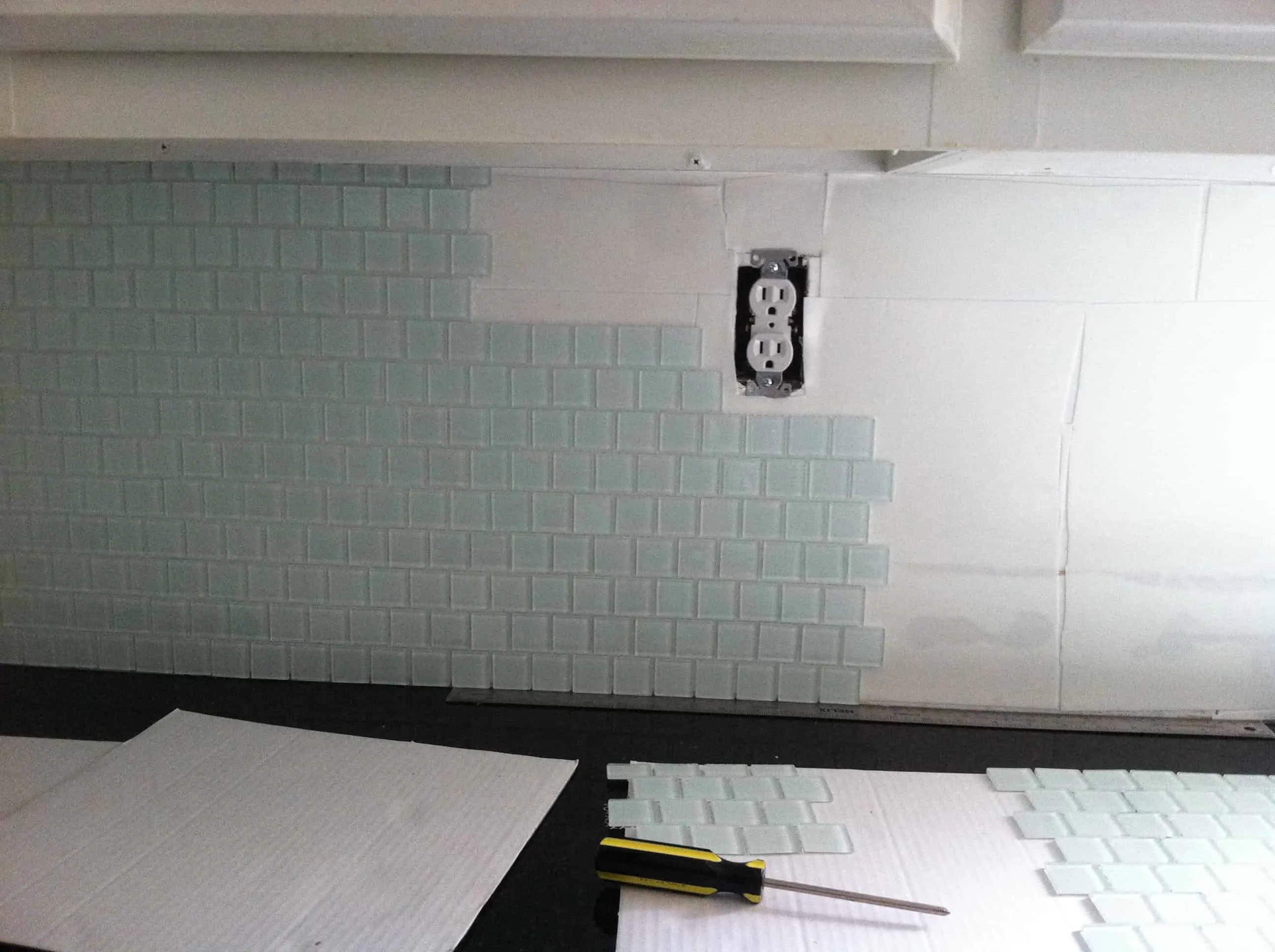 more glass tile sheets attached to the musselbound tile mat on the kitchen wall