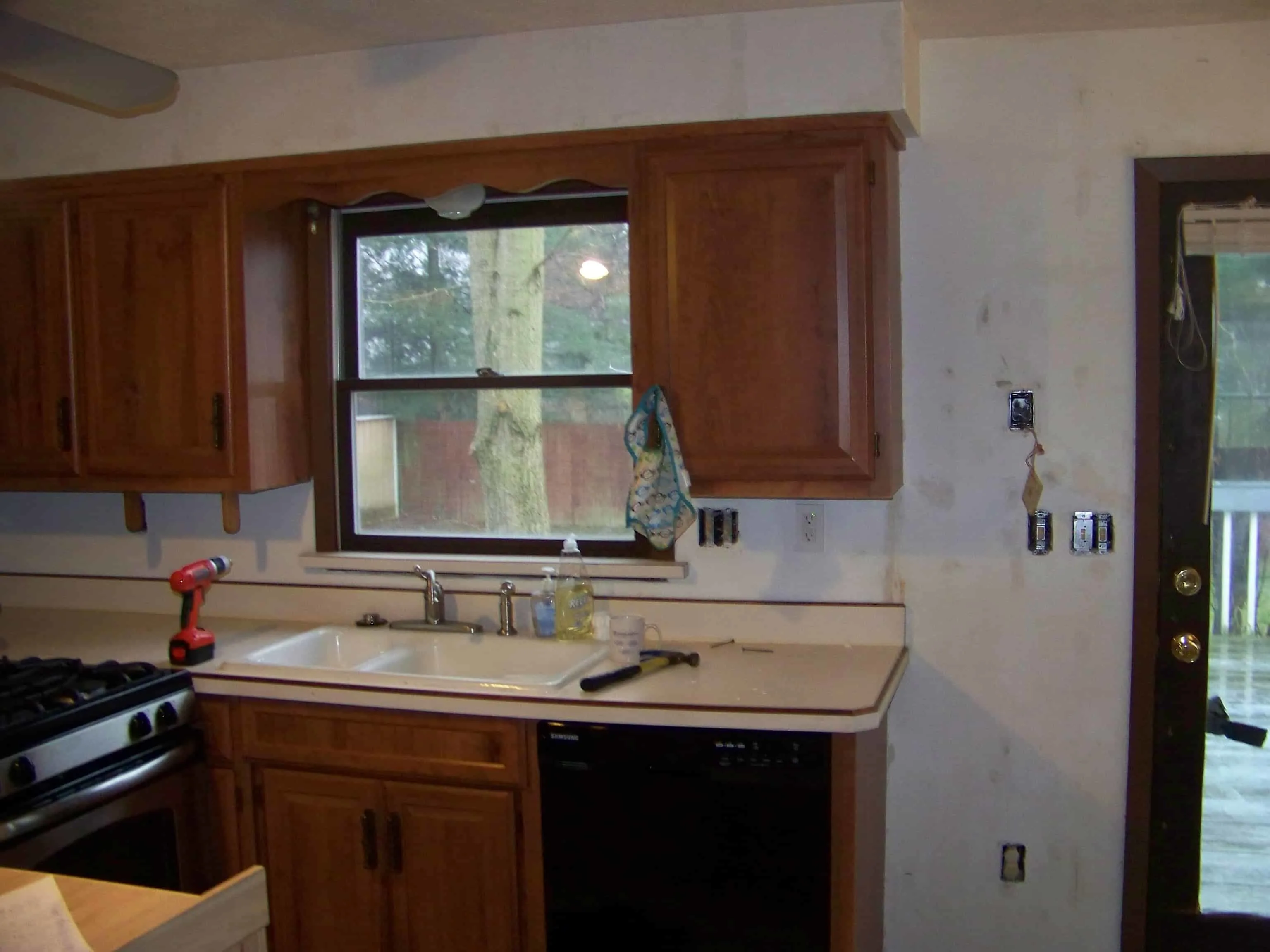 kitchen at the beginning of rennocation with old appliances and brown cabinets