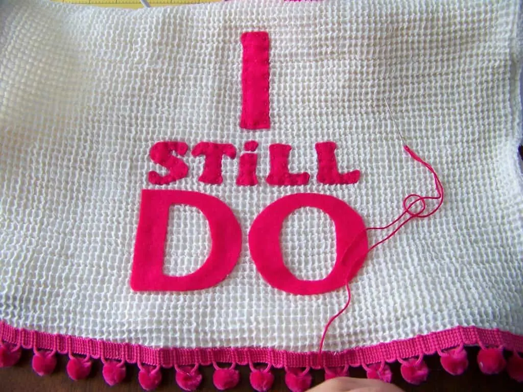 sewing the letters on the dishtowel