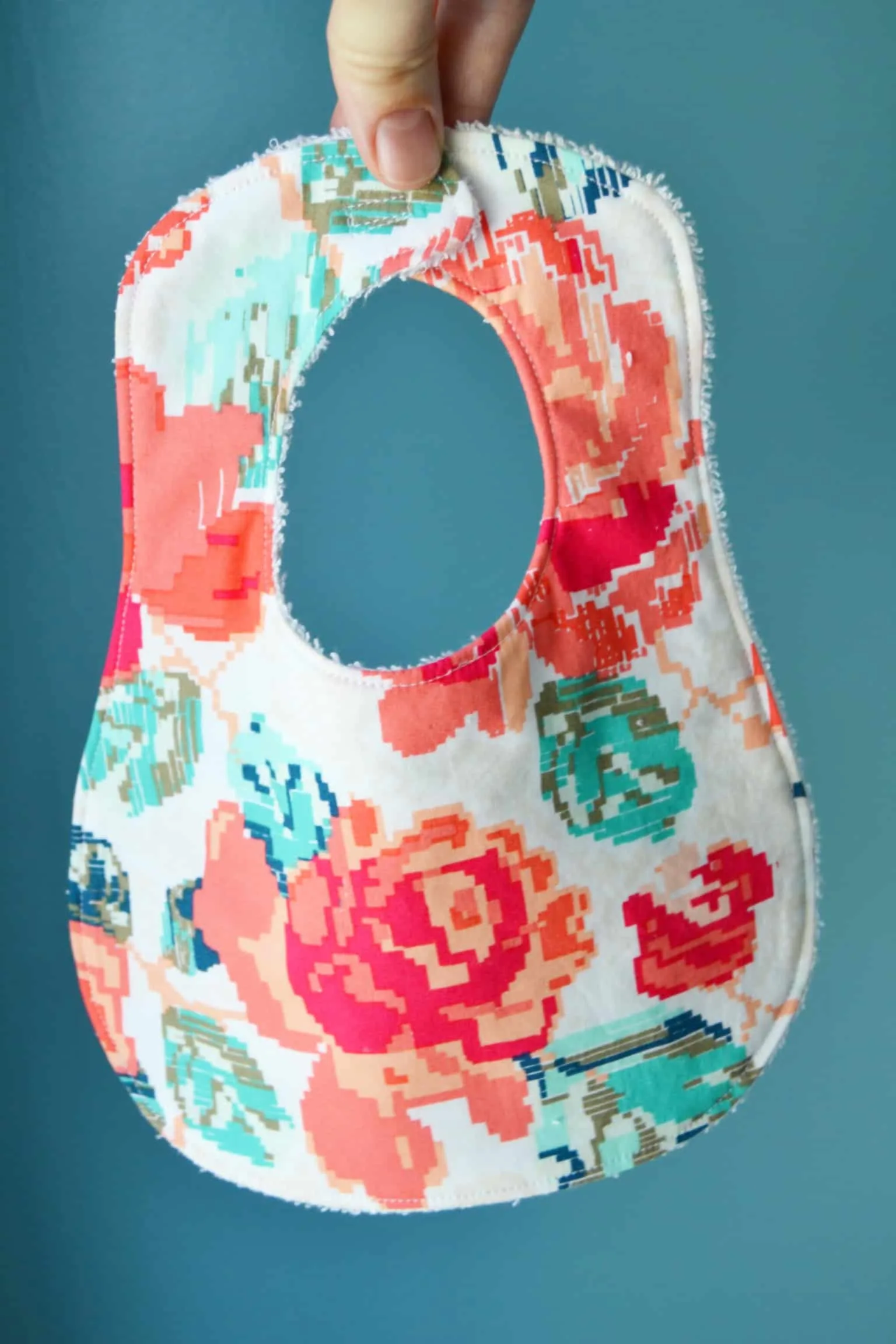 a hand holding the floral bib