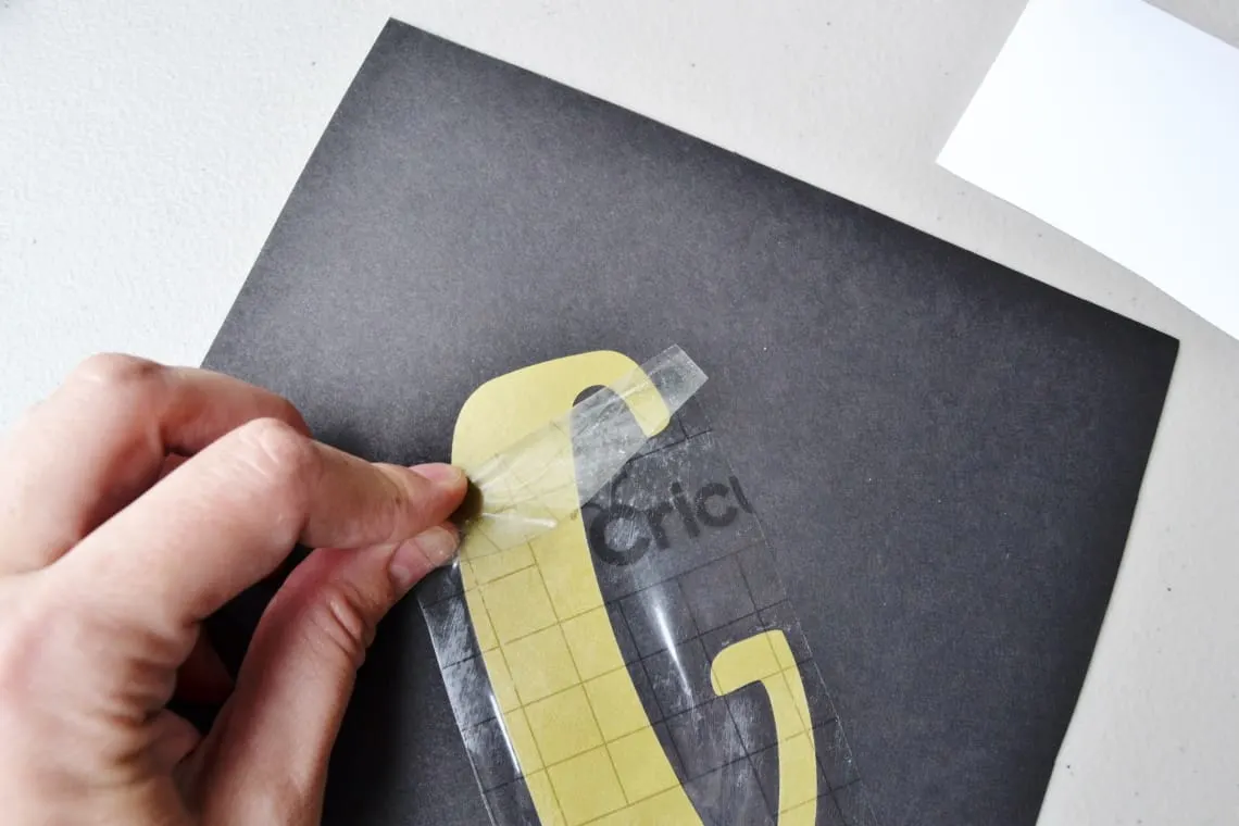 using the transfer tape to apply the vinyl to the paper for the banner
