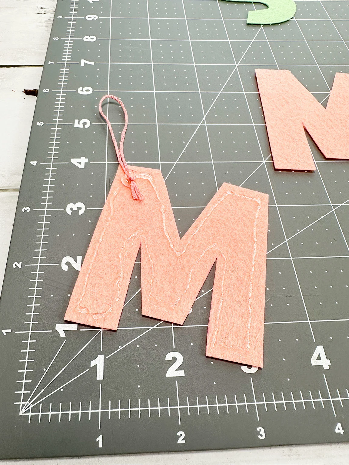 gluing down the embroidery floss on the felt letter