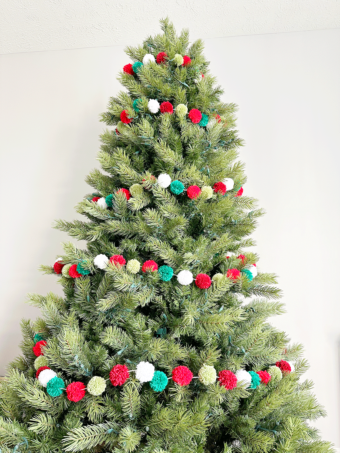Christmas tree with a DIY Pom Pom Garland on it