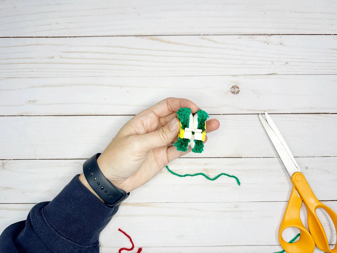 The Pom Pom maker with all the yarn cut along the groove