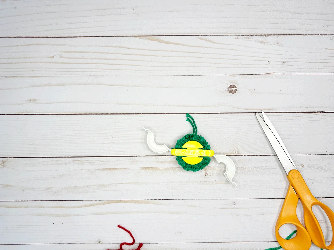 Opening the Pom Pom maker tool to release the finished Pom Pom