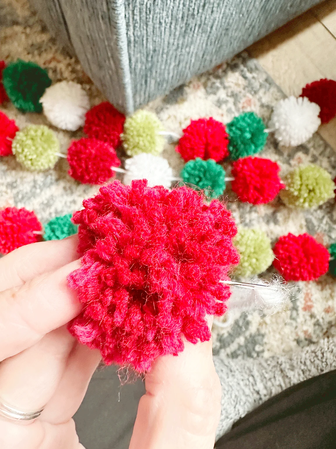 threading the needle through the center of the Pom Pom