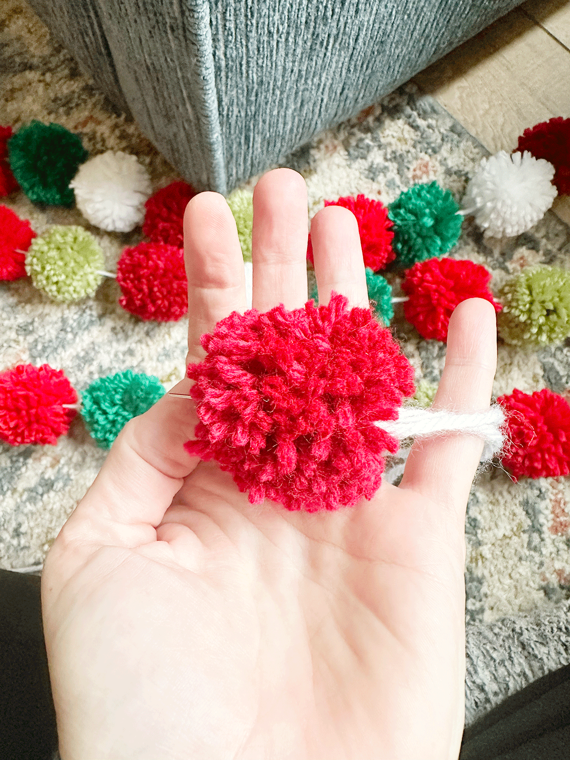 pushing the needle through the center of the Pom Pom