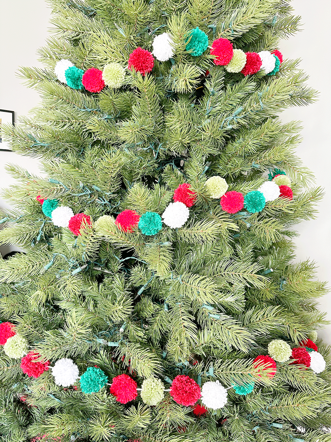A close up view of the Pom Poms on the DIY Pom Pom Garland on the Christmas tree