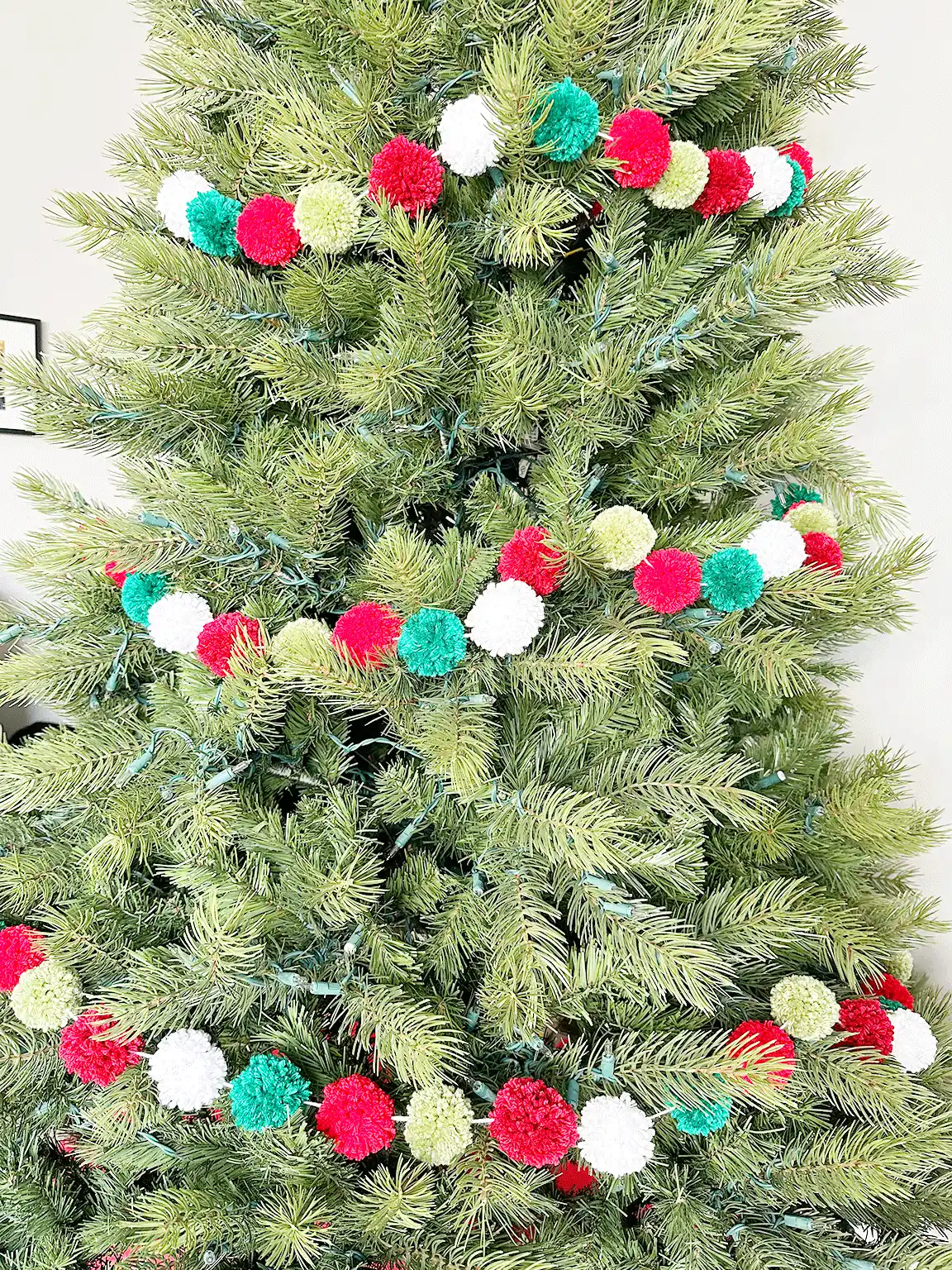 A close up view of the Pom Poms on the DIY Pom Pom Garland on the Christmas tree